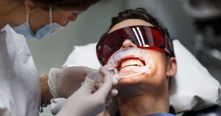 Patient receiving flexible cosmetic dental treatments with professional teeth whitening.